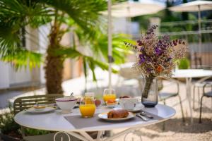 una mesa con comida y bebida y un jarrón de flores en Villa Sainte Anne, en Gigondas