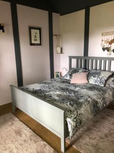 ein Schlafzimmer mit einem Bett mit einer grauen und weißen Bettdecke in der Unterkunft La cabane des coteaux in Gan