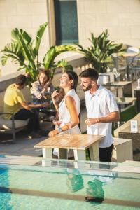 a man and woman standing next to a table next to a pool at Iberostar Selection Paseo de Gracia 4 Sup in Barcelona