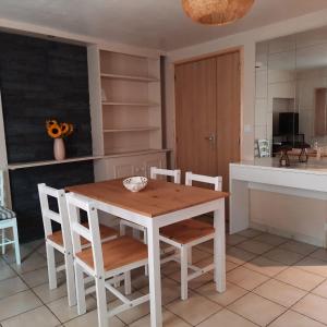 Una cocina con una mesa y sillas de madera. en Campaneta, en Saint-Martin-de-Brômes