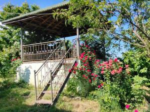 una escalera de madera en un jardín con flores rosas en Bon Apart en Quba