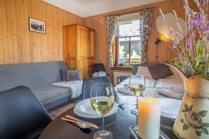 a living room with a table with glasses of wine at Pokoje Samo Centrum in Zakopane