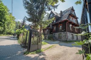 an old house with a gate in front of it at Pokoje Samo Centrum in Zakopane