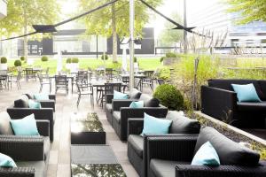 a patio with couches and tables and chairs at Novotel Zürich Airport Messe in Glattbrugg