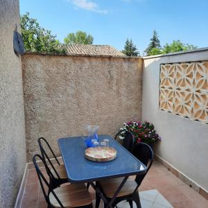 une table bleue et des chaises sur une terrasse dans l'établissement Campaneta, à Saint-Martin-de-Brômes