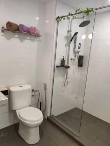 ein weißes Bad mit einer Dusche und einem WC in der Unterkunft SunKissed Paradise @ Marina View Villas PD in Port Dickson