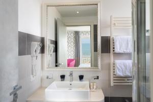 リド・ディ・イエゾロにあるHotel Sheilaのバスルーム(白い洗面台、鏡付)