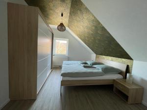 a bedroom with a bed in a room with a staircase at Moderne Wohnung mit Balkon inmitten der Lausitz in Bernsdorf