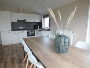 una cocina con una mesa de madera con un jarrón. en Camping de Vogel, en Hengstdijk