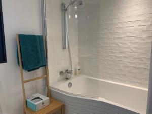 a white bathroom with a tub and a green towel at EL PEPITA, Sublime maison de ville, Rennes in Rennes +4 photos