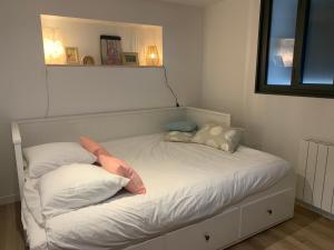 a bed with pillows on it in a room at EL PEPITA, Sublime maison de ville, Rennes in Rennes