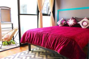 a bedroom with a large red bed with a window at Metro Hostal Boutique in Mexico City