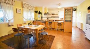 a kitchen with a wooden table and chairs at GALIHOST - Finca de Roque in O Grove +27 photos