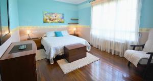 a bedroom with a bed and a table and a window at GALIHOST - Finca de Roque in O Grove