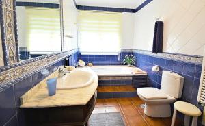 a blue and white bathroom with a tub and a toilet at GALIHOST - Finca de Roque in O Grove
