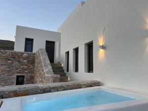 a swimming pool in front of a house at ZETINE SUITES SIKINOs in Sikinos