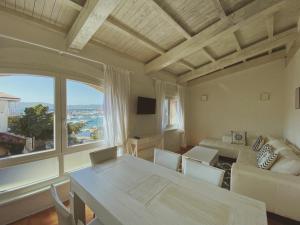 sala de estar con mesa y ventana grande en San Marco LT, en Porto Rotondo