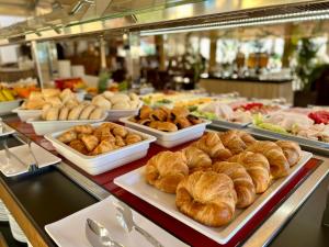 a buffet filled with different types of bread and pastries at Ramada Hotel & Suites by Wyndham Costa del Sol in Fuengirola