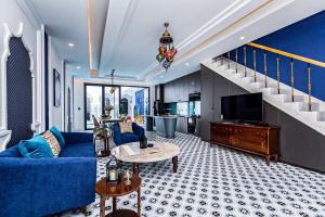 a living room with a blue couch and a tv at T-Maison Riad Villa, with Pool, Karaoke, Billiards, near beach, Vung Tau in Vung Tau