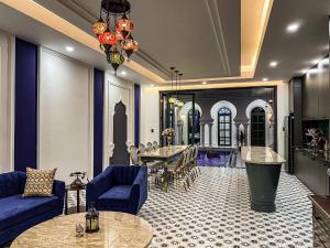 salon z niebieskimi kanapami i stołem w obiekcie T-Maison Riad Villa, with Pool, Karaoke, Billiards, near beach, Vung Tau w mieście Vung Tau