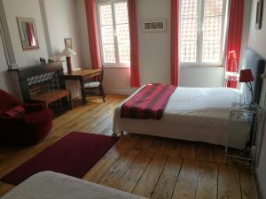 a bedroom with two beds and a desk with a chair at Le Renard d'Or in Montreuil-sur-Mer