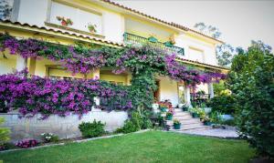 a house with purple flowers on the side of it at GALIHOST - Finca de Roque in O Grove