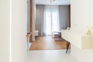 een woonkamer met een spiegel en een witte kamer bij New modern style home next to the train station in Thessaloniki