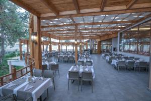 a dining room with tables and chairs and windows at Sueno Hotels Beach Side in Side