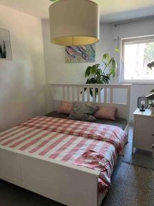 1 dormitorio con 1 cama con manta a rayas en stylische Maisonettewohnung Stadionnähe,Wald,Westfalenhalle, en Dortmund