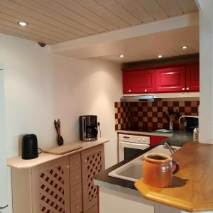 uma cozinha com armários vermelhos e uma bancada em Campaneta em Saint-Martin-de-Brômes