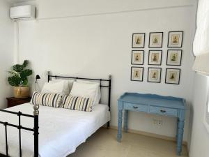 a bedroom with a bed and a blue end table at Saronida Boutique Villa Private Pool, Sea views, Lovely Gardens & Roof Terrace in Saronida +20 photos