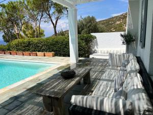 SaronidaにあるSaronida Boutique Villa Private Pool, Sea views, Lovely Gardens & Roof Terraceのプールサイドのパティオ(テーブル、椅子付)