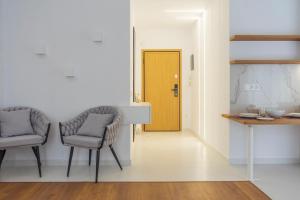 a hallway with two chairs and a yellow door at New modern style home next to the train station in Thessaloniki