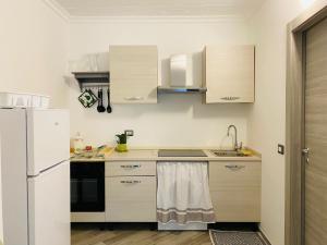 a kitchen with a white refrigerator and a sink at L'appartamento di Rita in Nettuno