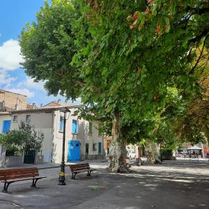 um parque com bancos e uma árvore e uma luz de rua em Campaneta em Saint-Martin-de-Brômes