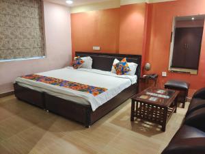a bedroom with a large bed and a table at HOTEL ORANGE INN in Patna