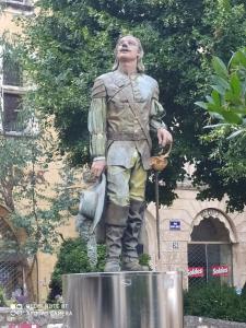 a statue of a man standing in front of a building at Appartement de charme en plein coeur de Bergerac in Bergerac