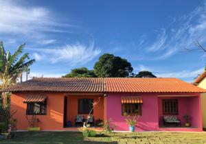 ein kleines Haus mit orangefarbenem Dach in der Unterkunft Casas Aconchegantes Temporada in Cabo Frio