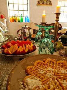 a table with a plate of waffles and fruit on it at B&B Bauernhofferien auf Møn in Askeby