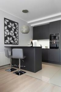 una cocina con armarios negros y electrodomésticos blancos en Elite Apartments Waterlane SPA, en Gdansk