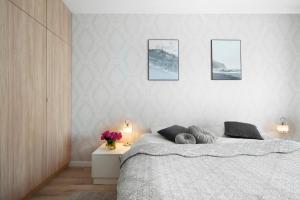 1 dormitorio con 1 cama y 3 cuadros en la pared en Elite Apartments Waterlane SPA, en Gdansk