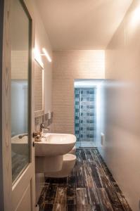 bagno con lavandino, servizi igienici e specchio di Casa Vacanze L'essenziale a Martina Franca