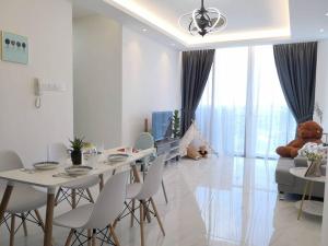 a white dining room with a table and chairs at Hanns&KingBed&WIFI&Pool& Parking&Sauna&Sunshine Classic Comfort Homstay in Sibu