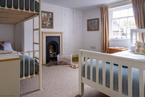a bedroom with a bunk bed and a fireplace at Two Sides Cottage in Lymington