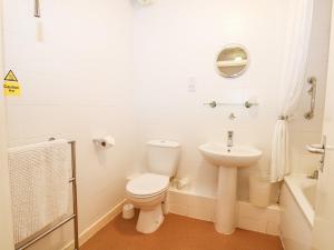 a white bathroom with a toilet and a sink at Marine Court Two Bedroom Second-floor Apartment 33 in Littlehampton +24 photos