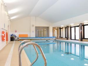 a swimming pool with chairs in a building at Flat 33 - Marine Court in Littlehampton
