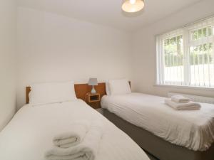 Dos camas en una habitación con sábanas y toallas blancas. en Harcombe House Bungalow 5, en Newton Abbot 45 fotos más