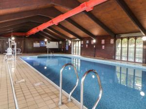 a large swimming pool in a building at Harcombe House Bungalow 5 in Newton Abbot