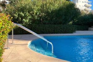 a swimming pool with a metal hand rail in it at HENRI CAMILLE REAL ESTATE - GOLDEN - one bedroom apt swimming pool in Cannes