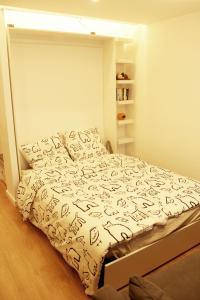 a bedroom with a bed with a white comforter at Cosy 1 bedroom Appt Proche de tout Metro à pied in Boulogne-Billancourt